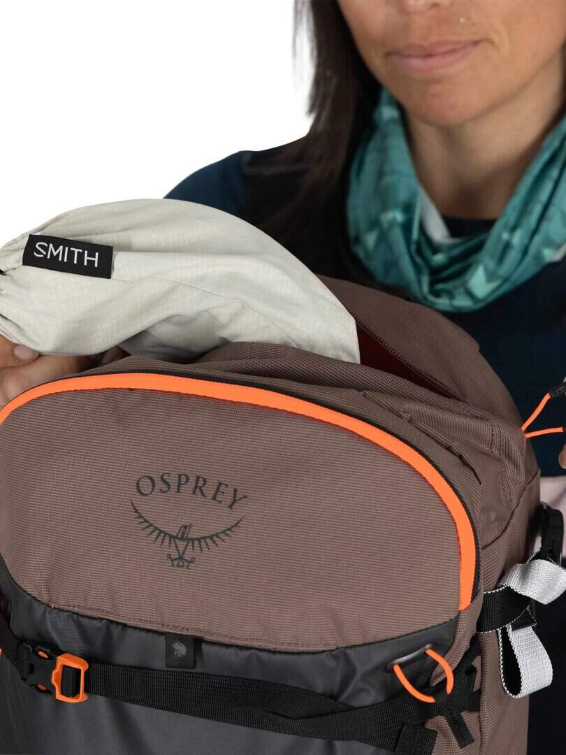 ALT текст: Мъж с раница Osprey, носи спортни аксесоари и екипировка за спорт и туризъм.