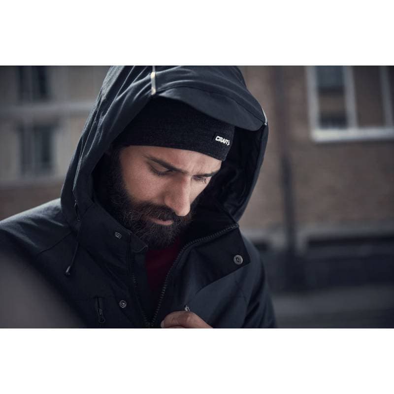 Мъж носи черна спортна качулка и яке Varrio Sport на градска улица.