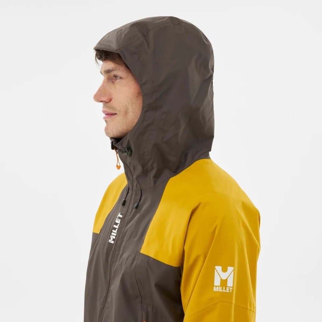 Мъж носи Millet ветроустойчива яке за outdoor активности.