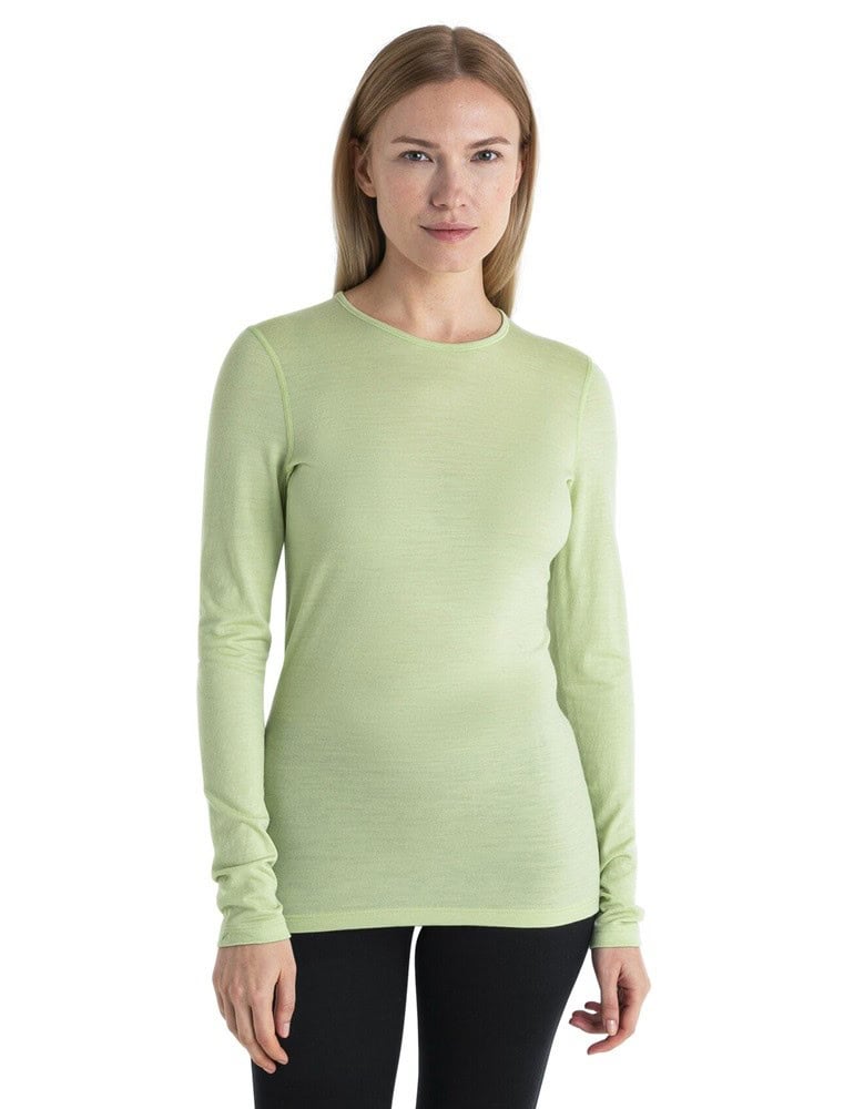 Жена носи светлозелен топ Icebreaker Merino 200 Oasis за спорт и активен начин на живот.