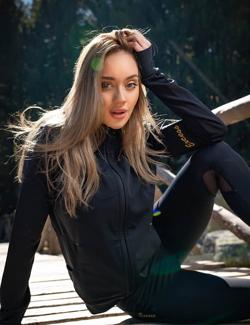 Стилна жена носи черен суитшърт Excess Black & Gold на открито.