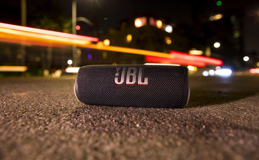 JBL Flip 6 безжична Bluetooth колона на асфалт в градска среда.